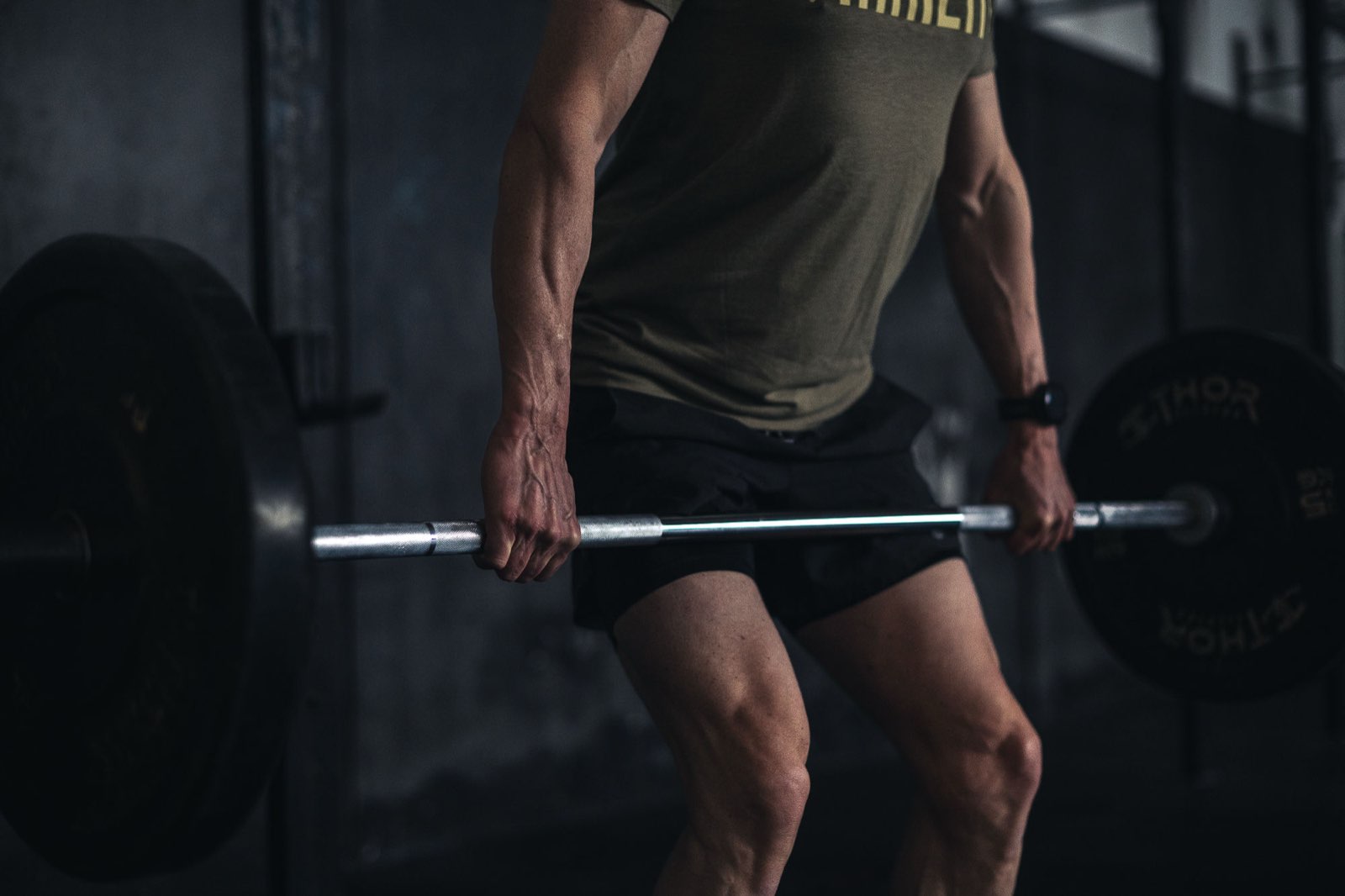 Close view of a deadlift lockout with hard-earned forearm veins in a Movement Rebels strength session