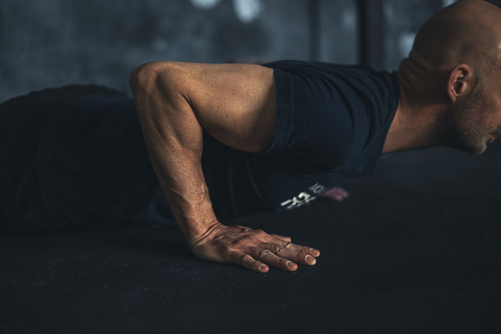 Low angle of a push-up mid-rep showing arm tension, Movement Rebels style strict bodyweight work